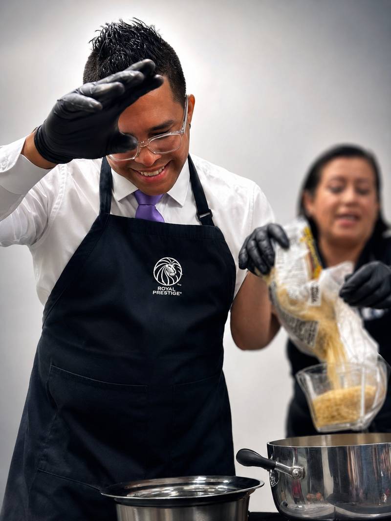 Tomas cocinando junto a una clienta